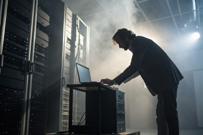 IT professional collecting devices with dramatic lighting and volumetric fog.