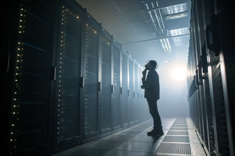 Technician in dimly lit server room with dramatic fog and detailed equipment.