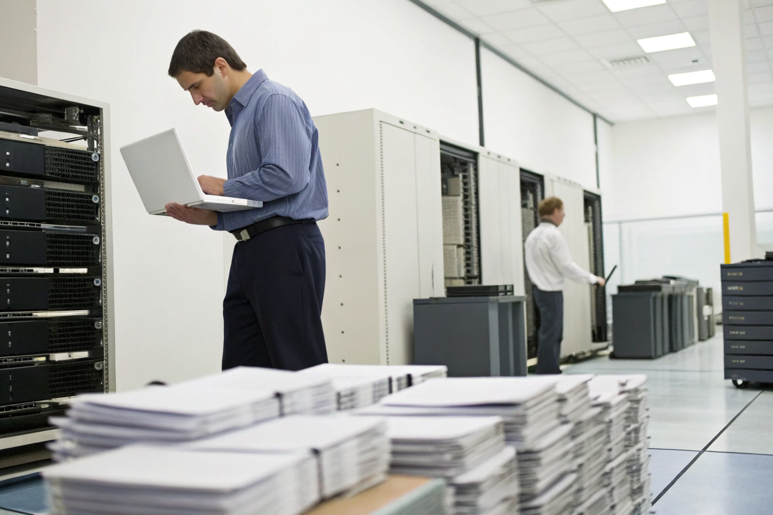 IT professionals documenting disposal procedures with equipment and forms.