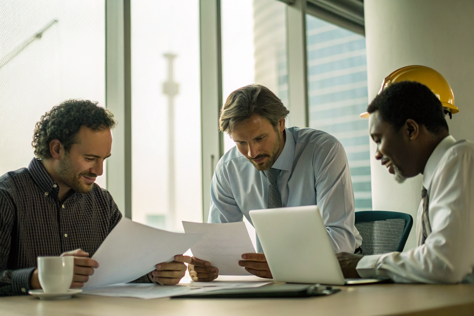 Workers discussing compliance documents in an office.